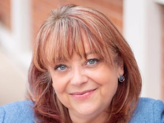 Woman wearing a white shirt and light blue jacket